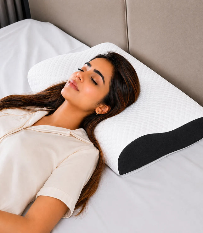 Woman lying on a bed with a white pillow featuring a black wedge
