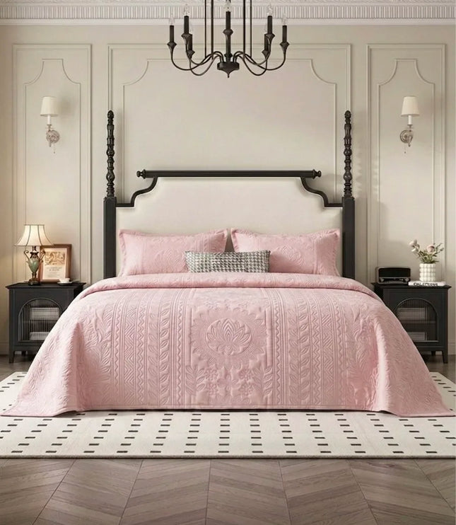 Pink quilted cover on a bed in a stylish bedroom with a chandelier and wall sconces.