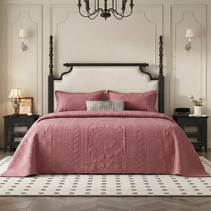 Bedroom with a four-poster bed covered in a pink quilt, nightstands, and a chandelier.