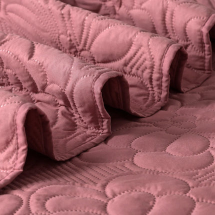 Close-up of a pink quilt with a textured pattern