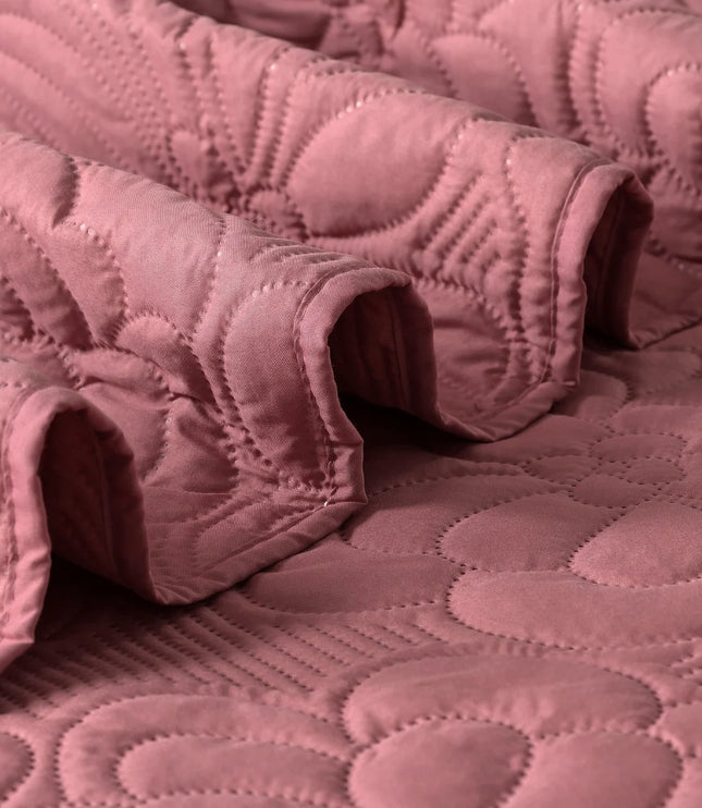 Close-up of a pink quilt with a textured pattern