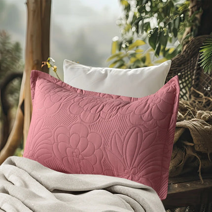 Pink textured pillow on a surface with a blurred natural background