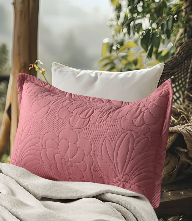 Pink textured pillow on a surface with a blurred natural background