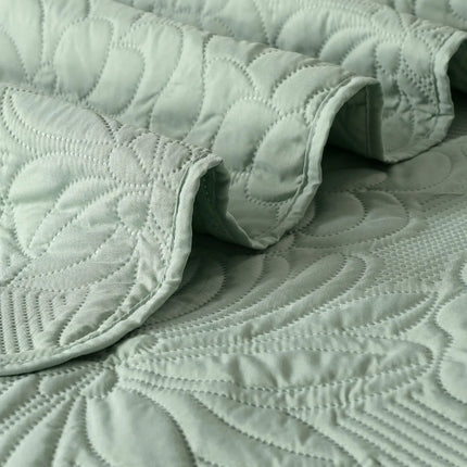 Quilted green fabric with a textured pattern