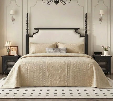 Neatly made bed with beige bedding in a stylish bedroom setting.