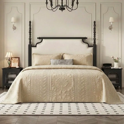 Neatly made bed with beige bedding in a stylish bedroom setting.