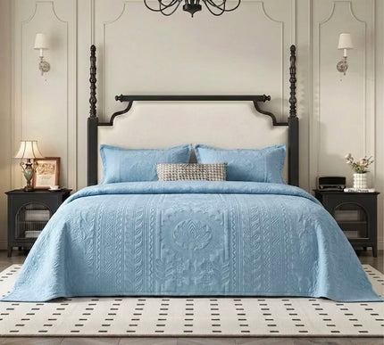 Bedroom with a bed covered in a blue quilt, wooden headboard, and decorative elements.