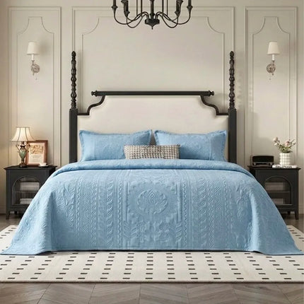 Bedroom with a bed covered in a blue quilt, wooden headboard, and decorative elements.