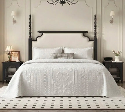 Neatly made bed with white bedding in a bedroom setting.