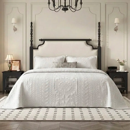 Neatly made bed with white bedding in a bedroom setting.