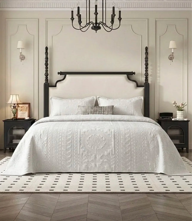 Neatly made bed with white bedding in a bedroom setting.
