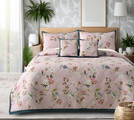 Floral quilt set on a bed in a bedroom with plants and decor.