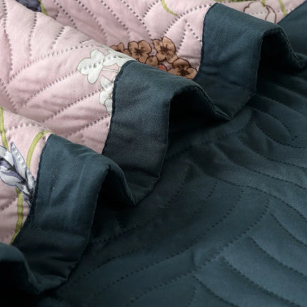 Dark green quilted fabric on a floral-patterned bedspread