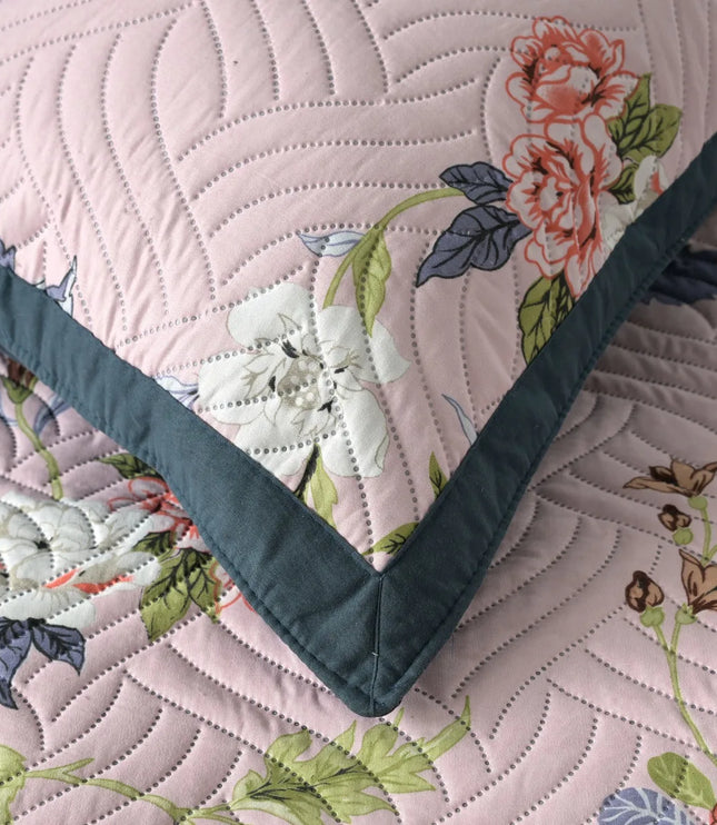 Floral quilt with green border on a matching fabric background