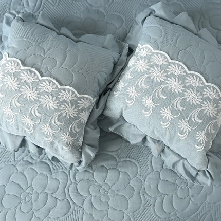 Gray pillows with lace trim on a textured gray fabric background
