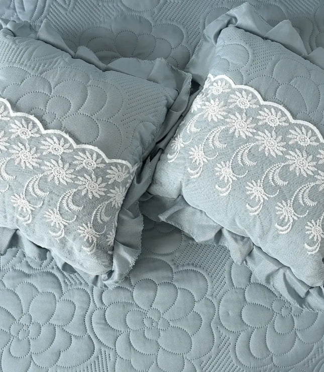 Gray pillows with lace trim on a textured gray fabric background