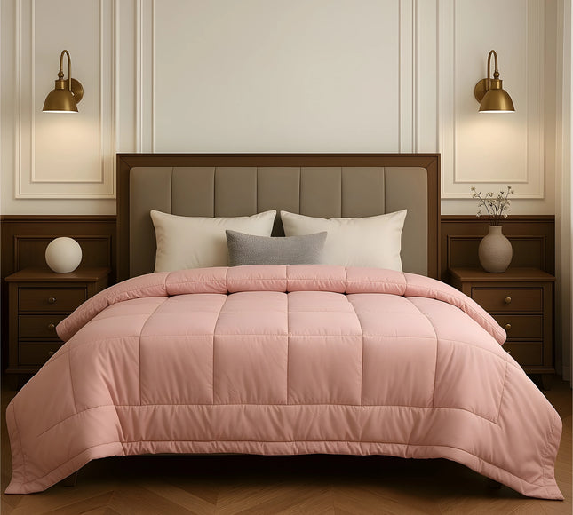 Bedroom with a neatly made bed featuring baby pink bedding and wooden furniture.