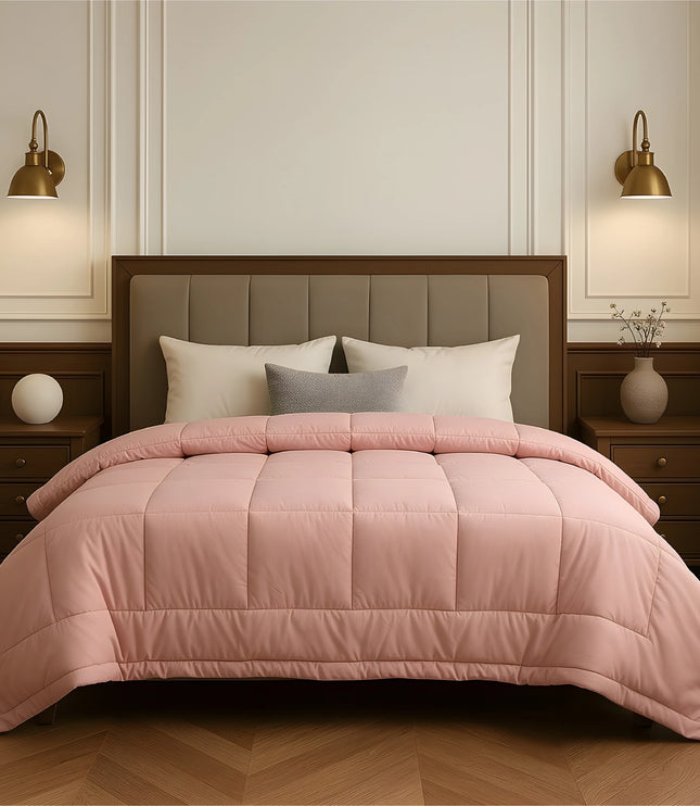 Bedroom with a neatly made bed featuring baby pink bedding and wooden furniture.