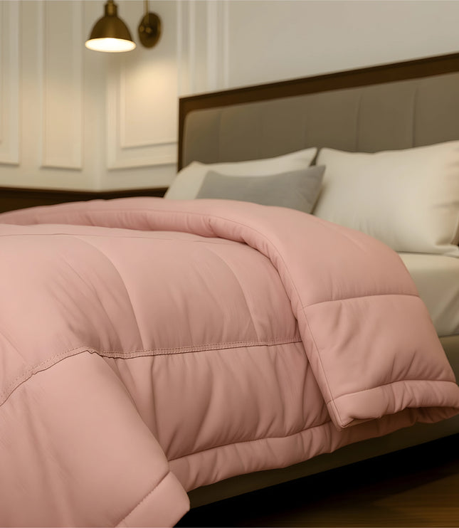 Bedroom with a neatly made bed featuring baby pink bedding and wooden furniture.
