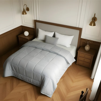 Bedroom with a neatly made bed featuring gray bedding and wooden furniture.