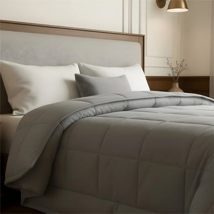 Bedroom with a neatly made bed featuring gray bedding and wooden furniture.