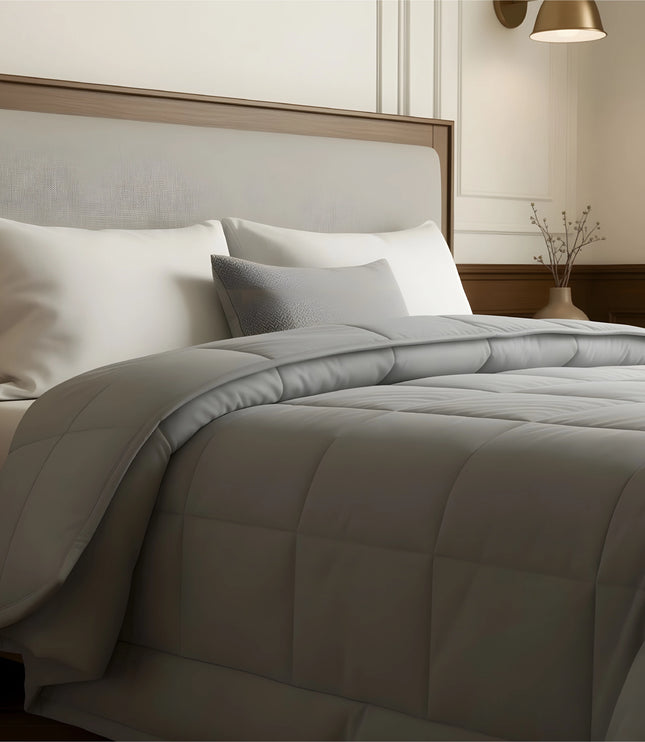 Bedroom with a neatly made bed featuring gray bedding and wooden furniture.