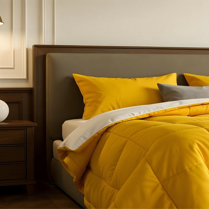 Bedroom with a neatly made bed featuring yellow bedding and wooden furniture.