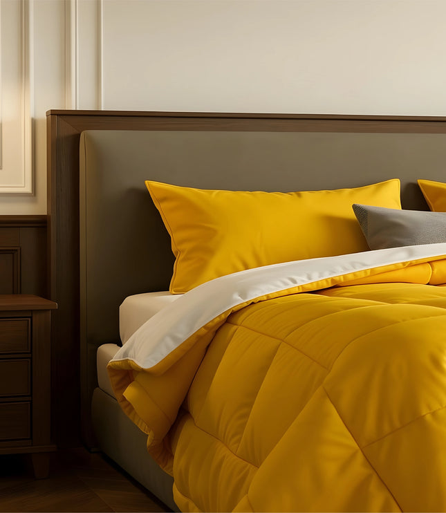 Bedroom with a neatly made bed featuring yellow bedding and wooden furniture.