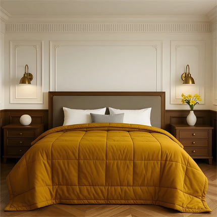 Bedroom with a neatly made bed featuring yellow bedding and wooden furniture.