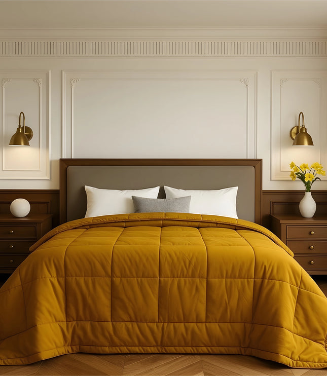 Bedroom with a neatly made bed featuring yellow bedding and wooden furniture.