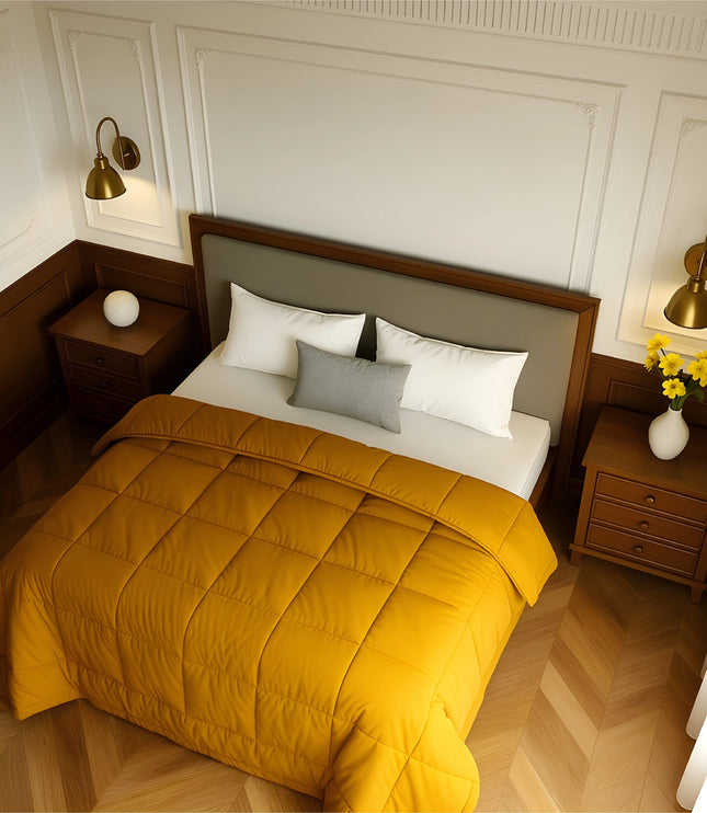 Bedroom with a neatly made bed featuring yellow bedding and wooden furniture.