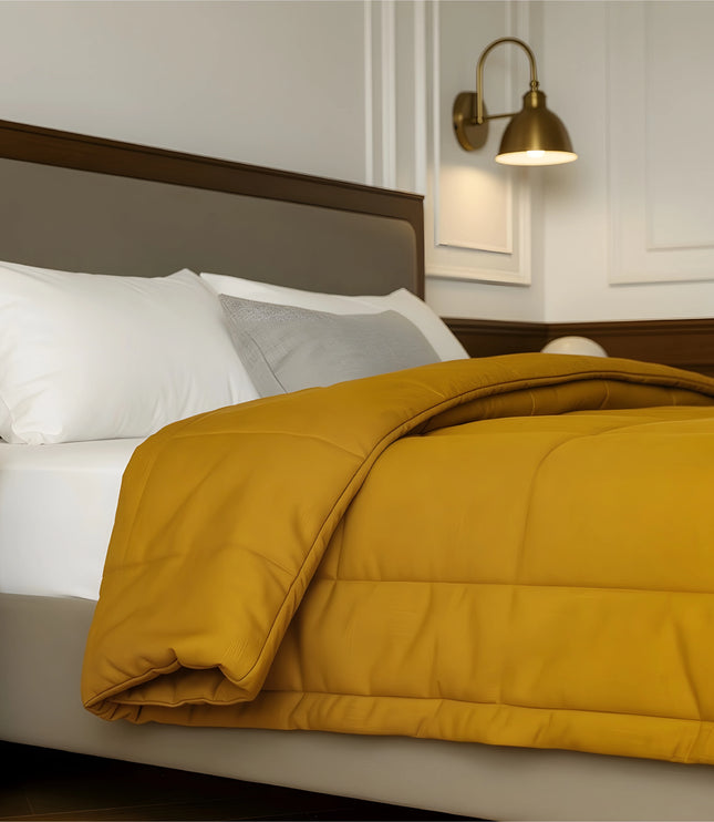 Bedroom with a neatly made bed featuring yellow bedding and wooden furniture.