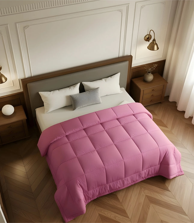 Bedroom with a bed covered in a pink comforter, wooden nightstands, and white walls.