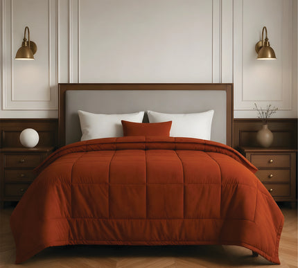 Bedroom with a neatly made bed featuring rust bedding and wooden furniture.