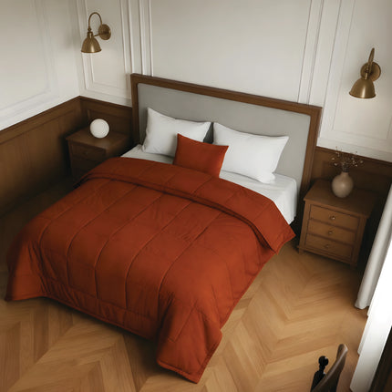 Bedroom with a bed featuring a rust comforter and white pillows, wooden nightstands, and wall lamps.