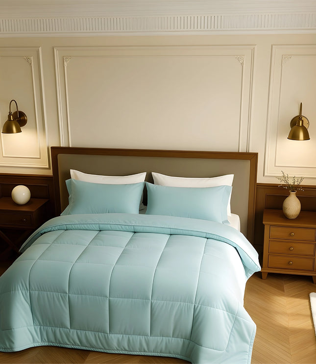 Bedroom with a bed covered in light blue comforter and pillows, wooden nightstands, and wall lamps.